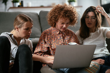 Girlfriends talking and laughing in office. Beautiful women drinking coffee in the office..