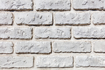 Brick wall made of old bricks, painted over with white lime.