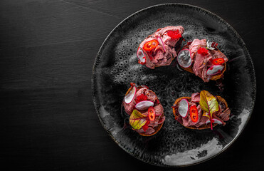 Appetizing bruschetta with roast beef on plate