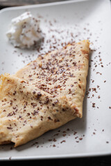 Delicious home made vegan crepes folded and sprinkled with chocolate