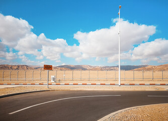 Empty road near Eilat airport parking lot with exit sign (English and Israeli translation), low...