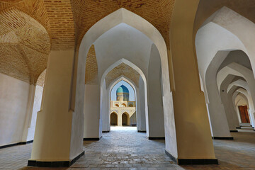 Fototapeta premium Arches of Poi Kalon mosque and its blue dome through archways, in Bukhara, Uzbekistan