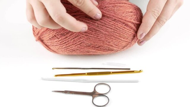 Crochet woolen threads.A set of hooks and scissors on the table.