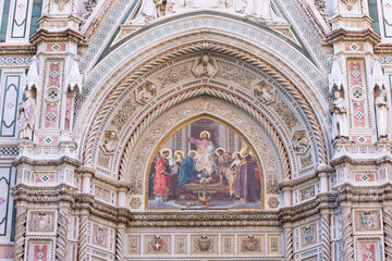 Fototapeta na wymiar A beautiful decorative painting on panel above the entrance door at the Duomo Santa Maria del Fiore, (Cathedral of Saint Mary of the Flower) in Florence, Italy