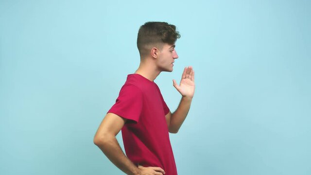 Young caucasian student man whispering gossip undertone, trying not to be heard