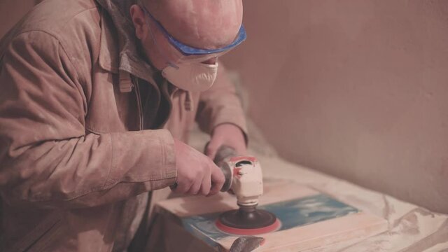 Man polishing wood. Epoxy table making process. Hipster handmade furniture design