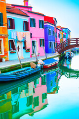 Fototapeta na wymiar Colorful houses on the canal in Burano island, Venice, Italy. Famous travel destination. Summer landscape