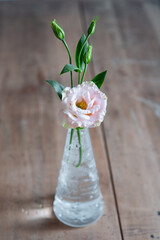 Eustoma flower in a vase on a wooden table