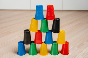 Disposable plastic cups are arranged in a pyramid. Pollution of the environment by human waste