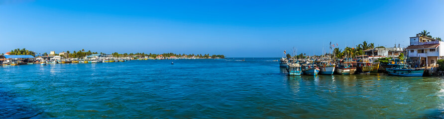 Fototapeta na wymiar A panorama view of boats moored in the lagoon in Negombo, Sri Lanka after returning from an early morning fishing trip