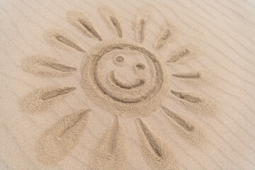 in Sand gezeichnete lachende Sonne