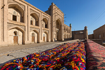 Old madrassa and Uzbek tapestry in Khiva, Uzbekistan.