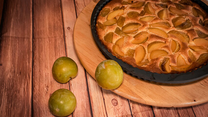 Fresh organic plum cake on the wooden table just made