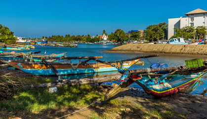 Fototapeta na wymiar A view of traditional outrigger canoes moored on the banks of a tributary to the lagoon in Negombo, Sri Lanka
