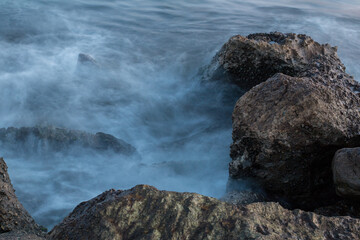 Naklejka premium lunga esposizione delle onde che si infrangono sulla scogliera