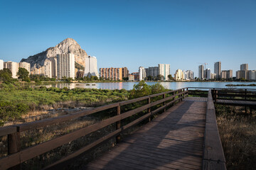 Footbridge in the salt lake of Calpe with the city skyline in the background, Alicante, Spain