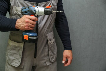 worker's hand holds wireless screwdriver