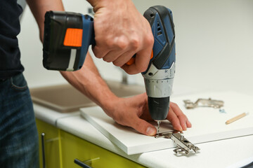 worker assembles furniture in the kitchen. furniture assembly service