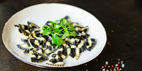 pasta farfalle black cuttlefish ink , durum wheat semola on a plate macaroni on the table serving portion size top view place copy space