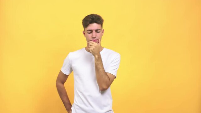 Young caucasian student man doubting and confused, thinking of an idea or worried about something