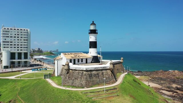 Beach view of Barra lighthouse, Salvador, Bahia, Brazil. Panorama view of Farol da Barra, lighthouse view in Salvador, Bahia, Brazil. Farol da Barra, lighthouse view in the beach. Beach scene.