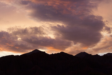 Enchanting sunset. View of the mountains silhouette at nightfall. Beautiful dusk colors in the sky and clouds.