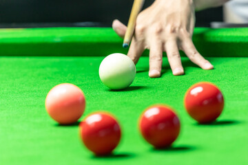 A man playing snooker in bar. Snooker player aiming snooker ball on snooker table.