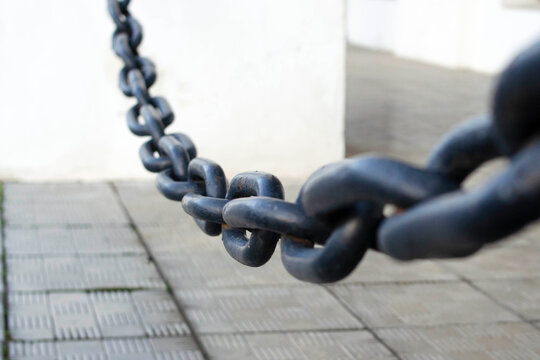 Black thick steel chain. Chain for fencing. Close-up. Background.