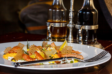 Rice with salmon slices and vegetables is on a plate
