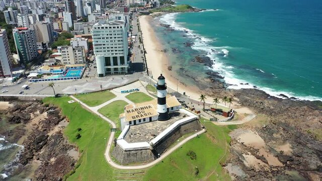 Beach view of Barra lighthouse, Salvador, Bahia, Brazil. Panorama view of Farol da Barra, lighthouse view in Salvador, Bahia, Brazil. Farol da Barra, lighthouse view in the beach. Beach scene.