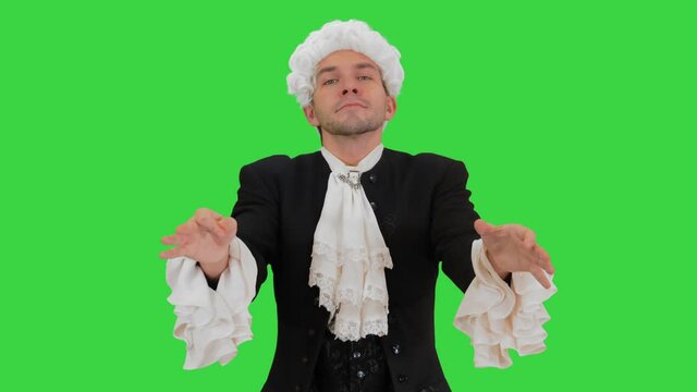 Man dressed like Mozart conducting expressively while looking at camera on a Green Screen, Chroma Key.