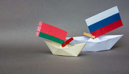 Fototapeta na wymiar paper boat with the flag of belarus and russia, europe.