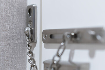 Metal door chain lock in hotel room, safety security protection when travel abroad
