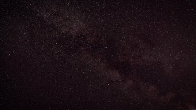 Night sky timelapse, many stars with satellites passing by, Milky way in region of Sagitta constellation faintly visible