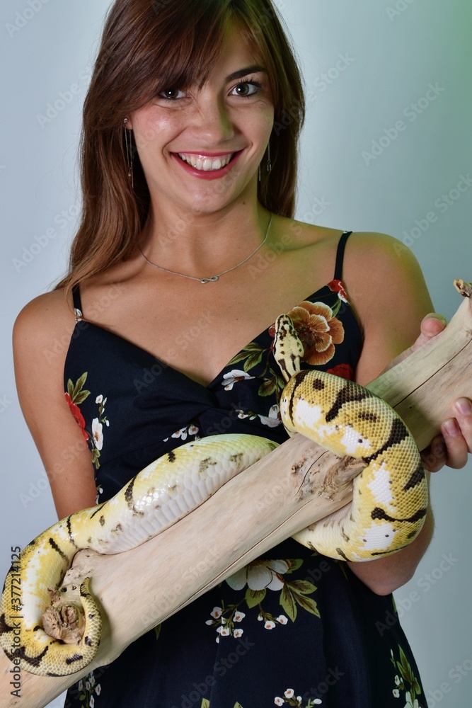 Wall mural Jeune femme accompagnée d'un gros serpent jaune