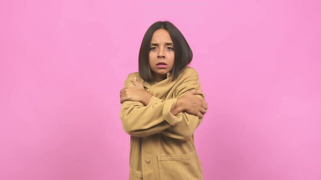 Young indian woman going cold, shivering and tired, probably due to a virus