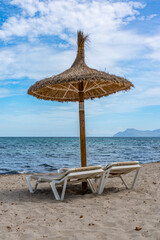 Empty beach loungers under straw parasols, a symbol of the tourism crisis caused by covid 19