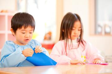 折り紙を折る幼稚園児
