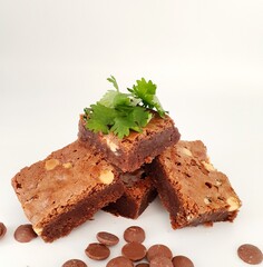 Chocolate brownies with chocolate chips dispersed on a white background.