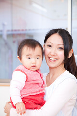 Fototapeta premium 保育士に抱っこされる保育園児