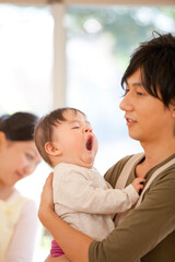 Fototapeta premium 保育士に抱っこされる保育園児