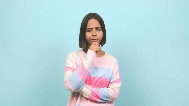 Young indian woman doubting and confused, thinking of an idea or worried about something