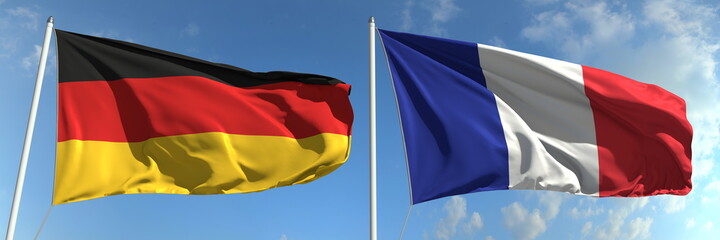 Flying flags of Germany and France on high flagpoles. 3d rendering