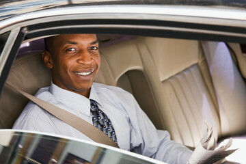 African businessman riding in back seat of car