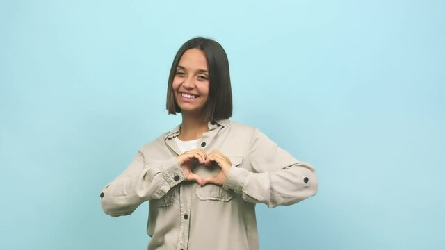 Young indian woman doing a heart with hands, expressing the concept of love and friendship