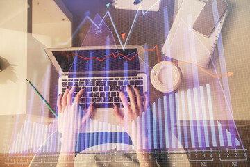 Double exposure of woman hands working on computer and forex chart hologram drawing. Top View....