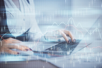 Double exposure of businesswoman hands typing on computer and forex graph hologram drawing. Financial analysis concept.