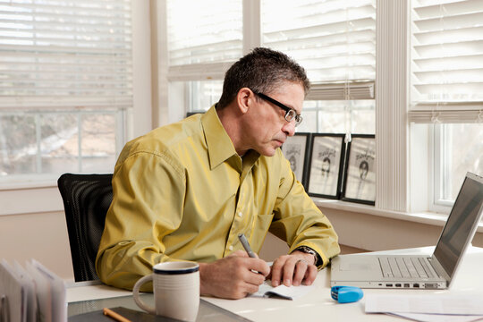 Hispanic man paying bills at desk