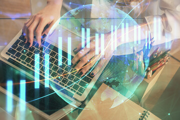 Double exposure of woman hands typing on computer and forex chart hologram drawing. Stock market invest concept.