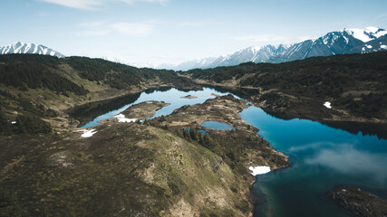 aerial drone shot of mountains and lake in alaska